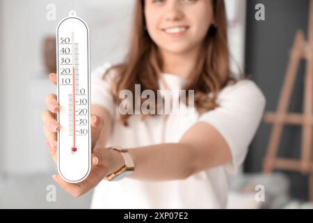 Frau mit Heimthermometer im Zimmer, Nahaufnahme Stockfoto