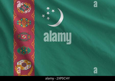Turkmenistan-Flagge auf gefaltetem, gewelltem Stoff aus altem Tuch in Nahaufnahme dargestellt Stockfoto