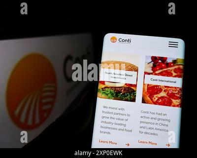 Stuttgart, Deutschland, 03-30-2022: Person, die ein Smartphone hält, mit Website des US-amerikanischen Unternehmens Continental Grain Company (CGC) auf dem Bildschirm vor dem Logo. Stockfoto