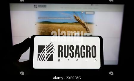 Stuttgart, Deutschland, 28.03.2022: Person mit Smartphone mit Logo des russischen Landwirtschaftsunternehmens Rusagro Group auf dem Bildschirm vor der Website. Stockfoto