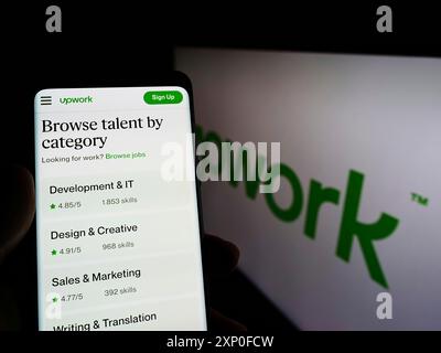 Stuttgart, Deutschland, 28.03.2022: Person, die ein Smartphone hält, mit Website der amerikanischen Freelancing-Plattform Upwork Global Inc. Auf dem Bildschirm mit Logo. Fokus Stockfoto