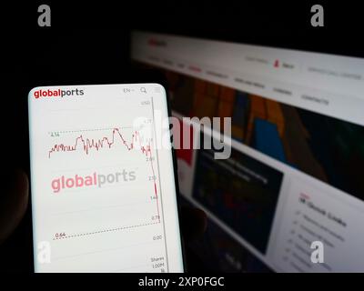 Stuttgart, Deutschland, 28.03.2022: Person, die ein Smartphone hält, mit Webseite des russischen Unternehmens Global Ports Investments (GPI) auf dem Bildschirm mit Monitor. Stockfoto