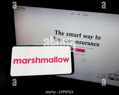 Stuttgart, Deutschland, 28.03.2022: Person, die ein Smartphone mit dem Logo der Firma Marshmallow Financial Services Limited auf dem Bildschirm vor der Website hält. Stockfoto