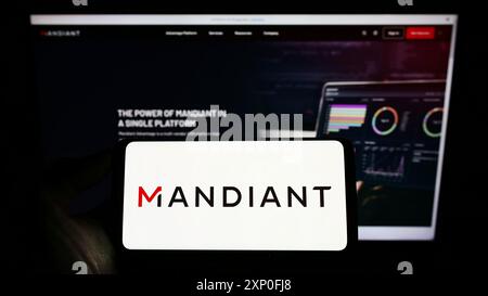 Stuttgart, Deutschland, 03.12.2022: Person, die ein Mobiltelefon mit dem Logo des US-amerikanischen Cybersicherheitsunternehmens Mandiant Inc. Auf dem Bildschirm vor der Unternehmenswebseite hält. Stockfoto