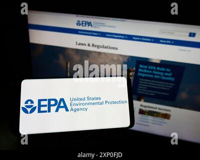 Stuttgart, Deutschland, 03.12.2022: Person, die ein Mobiltelefon mit dem Logo der American Environmental Protection Agency (EPA) auf dem Bildschirm vor dem Internet hält Stockfoto