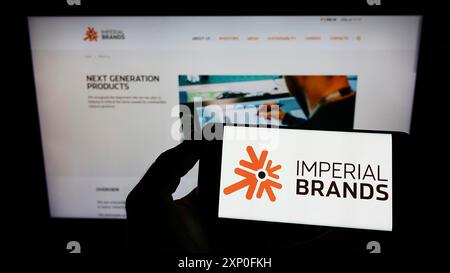 Stuttgart, Deutschland, 03.12.2022: Person mit Mobiltelefon mit Logo des britischen Tabakunternehmens Imperial Brands plc vor dem Geschäft Stockfoto