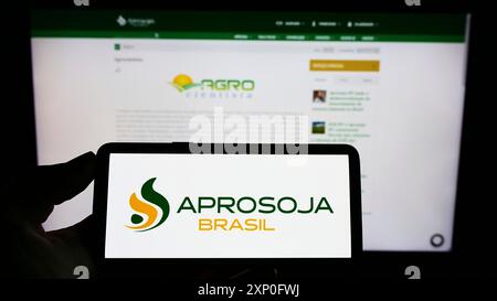 Stuttgart, Deutschland, 03.06.2022: Person mit Handy mit Logo des brasilianischen Landwirtschaftsunternehmens Aprosoja auf dem Bildschirm vor der Business-Website. Stockfoto