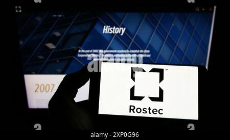 Stuttgart, Deutschland, 05-08-2022: Person, die ein Smartphone mit dem Logo der russischen Verteidigungsfirma Rostec auf dem Bildschirm vor der Website hält. Konzentrieren Sie sich auf das Telefon Stockfoto