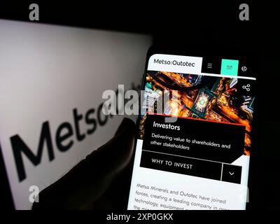 Stuttgart, Deutschland, 26.02.2022: Person, die ein Handy hält, mit Webseite des finnischen Maschinenbauunternehmens Metso Outotec Oyj vor dem Logo auf dem Bildschirm. Stockfoto