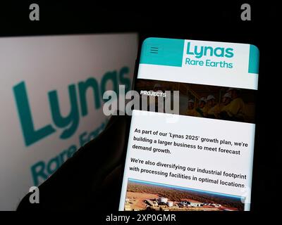 Stuttgart, Deutschland, 26.02.2022: Person, die ein Handy hält, mit Webseite des australischen Bergbauunternehmens Lynas Rare Earths Ltd. Auf dem Bildschirm mit Logo. Fokus Stockfoto