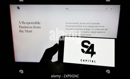 Stuttgart, Deutschland, 26.02.2022: Person, die ein Smartphone mit dem Logo der britischen Werbefirma S4 Capital plc auf dem Bildschirm vor der Website hält. Stockfoto