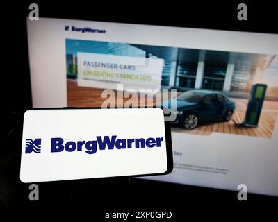 Stuttgart, 26.02.2022: Person, die ein Mobiltelefon mit dem Logo des US-amerikanischen Automobilkonzerns BorgWarner Inc. Auf dem Bildschirm vor der Unternehmenswebseite hält. Stockfoto