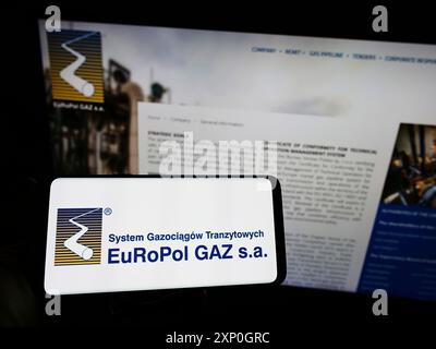 Person, die ein Smartphone mit dem Logo des polnischen Gasunternehmens Europol GAZ s.a. auf dem Bildschirm vor der Website des Unternehmens hält. Schwerpunkt auf dem Display des Telefons Stockfoto