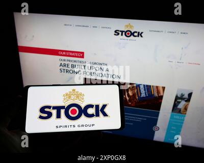 Person, die ein Mobiltelefon mit dem Logo der britischen Aktiengesellschaft Stock Spirits Group plc auf dem Bildschirm vor der Unternehmenswebseite hält. Schwerpunkt auf dem Display des Telefons Stockfoto