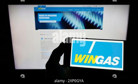 Person mit Smartphone und Logo der deutschen Gasverteilerfirma Wingas GmbH auf dem Bildschirm vor der Website. Schwerpunkt auf dem Display des Telefons Stockfoto