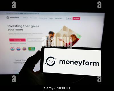 Stuttgart, Deutschland, 02.11.2022: Person, die ein Smartphone mit dem Logo der britischen Investmentberatungsgesellschaft Moneyfarm auf dem Bildschirm vor der Website hält. Stockfoto