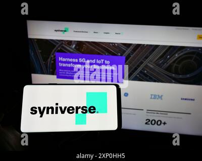 Stuttgart, Deutschland, 02.11.2022: Person, die ein Mobiltelefon hält, mit dem Logo des amerikanischen Telekommunikationsunternehmens Syniverse Technologies LLC auf dem Bildschirm vor dem Bildschirm Stockfoto