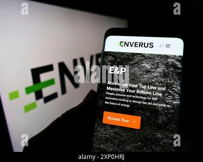Stuttgart, Deutschland, 15.01.2022: Person, die ein Mobiltelefon hält, mit einer Webseite des US-Softwareunternehmens Drillinginfo Inc. (Enverus) auf dem Bildschirm mit Logo. Fokus Stockfoto