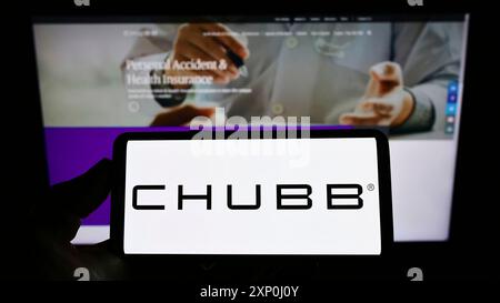 Stuttgart, Deutschland, 02.06.2022: Person mit Handy mit Logo der schweizerischen Versicherung Chubb Limited auf dem Bildschirm vor der Unternehmenswebseite. Stockfoto