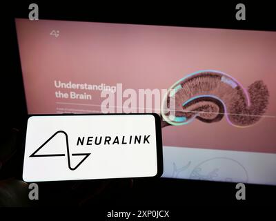 Stuttgart, Deutschland, 01-30-2022: Person, die ein Mobiltelefon mit dem Logo des amerikanischen Neurotechnologie-Unternehmens Neuralink Corp vor der Webseite hält. Stockfoto