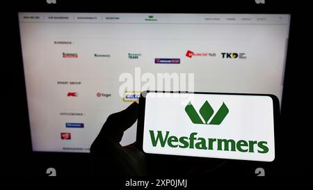 Stuttgart, Deutschland, 29.01.2022: Person, die ein Mobiltelefon mit dem Logo des australischen Konzerns Wesfarmers Limited vor dem Geschäft hält Stockfoto