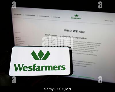 Stuttgart, Deutschland, 29.01.2022: Person, die ein Smartphone mit dem Logo des australischen Konzerns Wesfarmers Limited auf dem Bildschirm vor der Website hält. Stockfoto