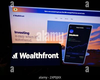 Stuttgart, Deutschland, 28.01.2022: Person, die ein Smartphone mit dem Logo des US-amerikanischen Fintech-Unternehmens Wealthfront Corporation auf dem Bildschirm vor der Website hält. Stockfoto