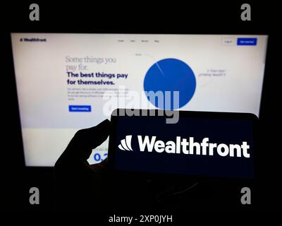 Stuttgart, Deutschland, 28.01.2022: Person, die ein Mobiltelefon mit dem Logo der amerikanischen Fintech-Firma Wealthfront Corporation auf dem Bildschirm vor der Webseite hält. Stockfoto