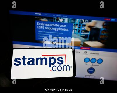 Stuttgart, Deutschland, 23.01.2022: Person, die ein Mobiltelefon mit dem Logo der US-amerikanischen Reederei Stamps.com Inc. Auf dem Bildschirm vor der Unternehmenswebseite hält. Stockfoto