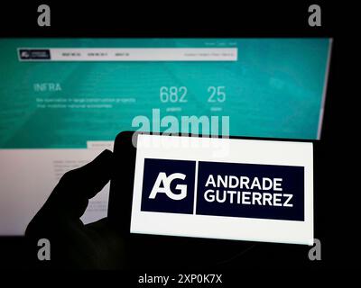 Stuttgart, Deutschland, 23.01.2022: Person, die ein Smartphone mit dem Logo des brasilianischen Konzerns Andrade Gutierrez S.A. auf dem Bildschirm vor der Website hält. Stockfoto
