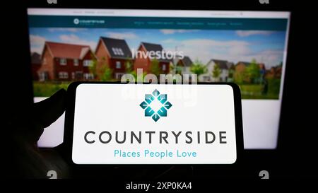 Stuttgart, Deutschland, 16.01.2022: Person, die ein Smartphone mit dem Logo des britischen Unternehmens Country Properties plc auf dem Bildschirm vor der Website hält. Stockfoto