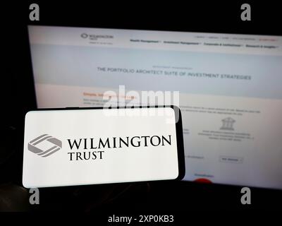 Stuttgart, Deutschland, 16.01.2022: Person, die ein Mobiltelefon mit dem Logo der amerikanischen Finanzgesellschaft Wilmington Trust Company auf dem Bildschirm hält Stockfoto