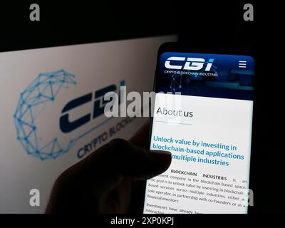 Stuttgart, Deutschland, 15.01.2022: Person, die ein Handy hält, mit Webseite des französischen Unternehmens Crypto Blockchain Industries (CBI) auf dem Bildschirm mit Logo. Fokus Stockfoto