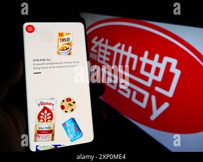 Stuttgart, Deutschland, 01-08-2022: Person, die ein Mobiltelefon hält, mit Website der Firma Vitasoy International Holdings Ltd. Auf dem Bildschirm vor dem Logo. Stockfoto