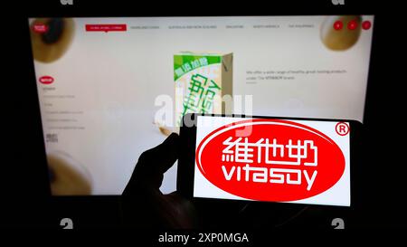 Stuttgart, Deutschland, 01-08-2022: Person, die ein Smartphone mit dem Logo der Firma Vitasoy International Holdings Ltd. Auf dem Bildschirm vor der Website hält. Stockfoto