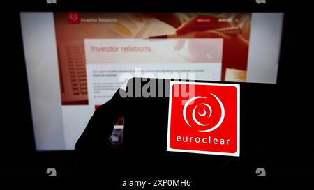 Stuttgart, Deutschland, 01.06.2022: Person, die ein Smartphone mit dem Logo des belgischen Finanzunternehmens Euroclear Group auf dem Bildschirm vor der Website hält. Fokus Stockfoto