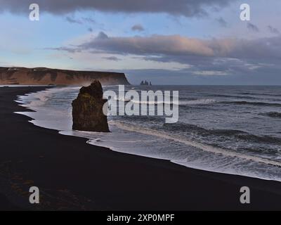 Atemberaubender Blick über die vulkanische Landschaft mit schwarzem Strand Reynisfjara in der Nähe der Route 1 an der Südküste Islands mit der berühmten Felsformation Arnardrangur Stockfoto