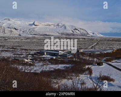 Skaftafell, Island, 26.03.2021: Wunderschöner Blick aus der Vogelperspektive auf das Besucherzentrum Skaftafellsstofa im Vatnajoekull-Nationalpark im Winter mit den zerklüfteten Felsen Stockfoto