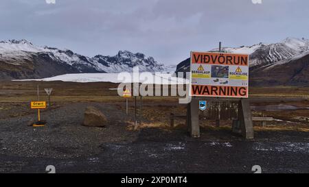 Svinafellsjoekull, Island, 25.03.2021: Gesperrte Straße nach Svinafellsjoekull mit großem Bergsturz-Warnschild in der Wintersaison mit Gletscher Stockfoto