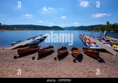 Eine malerische Szene mit bunten Tretbooten und Holzbooten auf einem Bootssteg vor dem Schluchsee, umgeben von Bergen, Frühling, Schluchsee Stockfoto
