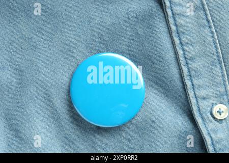 Blaues Knopfabzeichen auf dem Jeansshirt, Ansicht von oben. Modell für Design Stockfoto