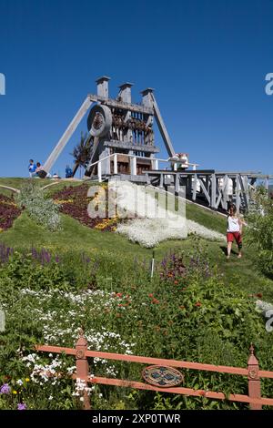 Landschaftsblumen machen Schmetterlingsbild auf dem Rasen vor einer alten kalifornischen Briefmarkenmühle mit zwei Batterien, Old Lexington Gardens, Butte, MT. Stockfoto