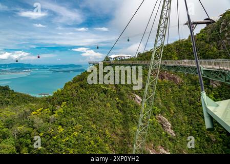 Langkawi-Seilbahnen fahren durch die spetaculare Landschaft auf der Insel, von der Stahlseilbrücke aus gesehen, die sich hoch über die bewaldeten Gipfel des Mat CI schlängelt Stockfoto