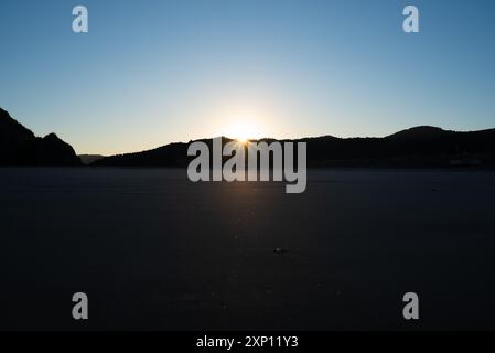 Erste Sonnenstrahlen auf einem leeren Te Hunga (Bethells Beach) Stockfoto