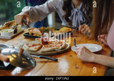 Hausgemachte Pizzen werden in einem Holzkohleofen zubereitet und auf Holztabletts im Restaurant serviert. Hausgemachte Pizza mit gesunden Zutaten und machen Pizza Top Stockfoto