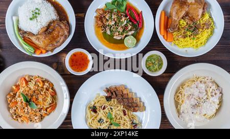 Viele Gerichte werden auf weißen Tellern serviert und dann auf Holztischen für Freunde und Familienmitglieder zubereitet, die sie auf der Party genießen können. Zubereiten von viel Essen Stockfoto