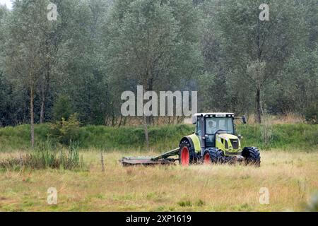 Landwirt, der Gras auf einer Wiese für die Heuproduktion im Rother Valley East Sussex UK schneidet Stockfoto