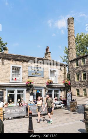 Ein junges Paar spaziert vorbei am Shoulder of Hammel Pub in Hebden Bridge, Yorkshire, England, Großbritannien Stockfoto