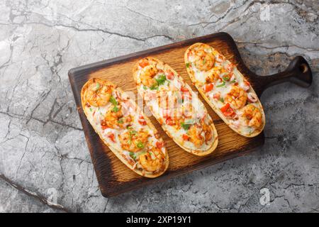 Mozzarella Shrimps öffnen Sandwiches, die auf italienischem Knoblauchbrot gebacken werden, auf einem Holzbrett auf dem Tisch. Horizontale Draufsicht von oben Stockfoto