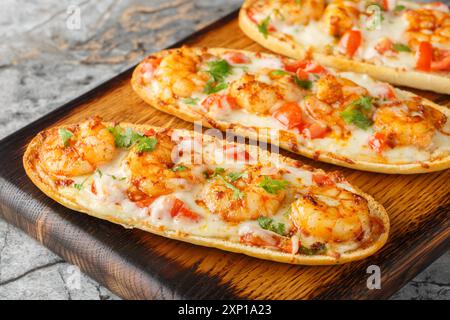 Mozzarella Shrimps öffnen Sandwiches, die auf italienischem Knoblauchbrot gebacken werden, auf einem Holzbrett auf dem Tisch. Horizontal Stockfoto